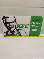 Full view of rectangular KFC drive-thru sign with measuring tape