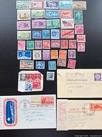 Overview of stamps arranged by colour and denomination, plus three postal covers