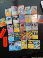 All 27 Pokémon cards and 2 orange stands laid out in rows