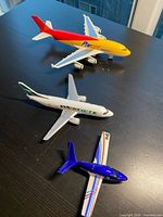 Three metal toy airplanes displayed on table