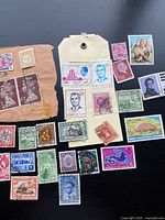 Group of stamps on black background showing variety of countries and designs