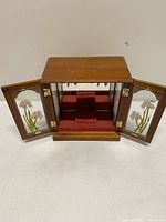 Cabinet with doors open displaying interior compartments and stained glass panels