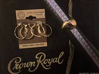 Earrings on card, ring on mandrel showing size, Crown Royal bag background