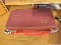 Two Scrabble boxes, maroon vintage and red Hasbro