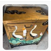 Front view of cabinet showing hand-painted cranes, lotus and gold leaf