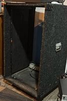 Front angled view of empty carpeted audio rack road case showing interior and caster base