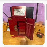 Cabinet closed except top lid raised showing mirror, main brass-latched door partly open