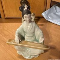 Front view of porcelain woman playing Guqin