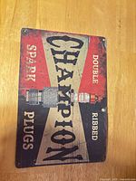 Front view of Champion Spark Plugs metal sign showing full graphic and wear