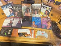 All ten DVDs and three hair extension packages laid out on desk