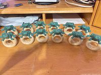 Twelve frog ceramic napkin rings arranged on tabletop