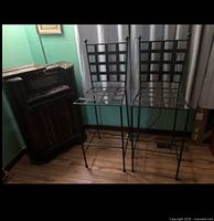 Two black metal bar chairs next to cabinet