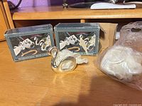 Two International Silver Company boxes, loose swan napkin ring and packaging visible