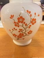 Front view showing orange blossom motif on white milk glass body