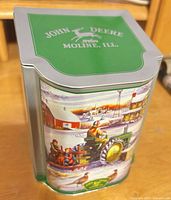 Full view showing hinged slope lid with John Deere logo and winter scene graphics