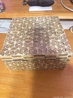 Closed square box showing floral inlay pattern on lid and sides
