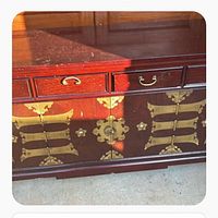 Front view showing three drawers and brass-decorated front panel