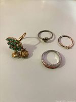 Four rings arranged; chrysoprase cluster, heart band, bypass ring, ruby eternity band visible