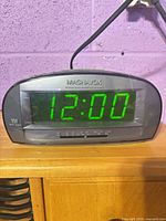 Front view showing Magnavox digital clock radio lit at 12:00