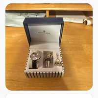 Open Sailor Jane box showing wristwatch, wine stopper, handbag charm