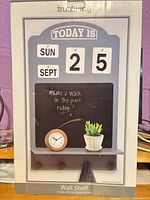 Front of unopened box showing wall shelf design and brand