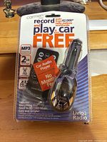 Front of sealed retail package showing Carmen by Livio car audio player and key specs