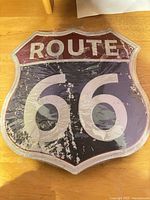 Front of pressed metal Route 66 sign showing graphics and protective wrap