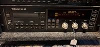 Front view of Tascam DA-30 DAT deck in rack, showing controls and display