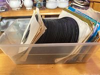 Plastic bin holding stack of 7-inch records in sleeves