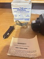 Front view of Kirk's Truck Alarm, 12-V plug, original box, warranty card visible
