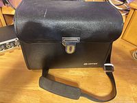 Front view of Optex camera bag with latch and strap