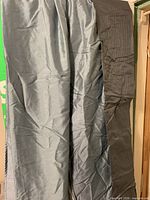 Front view of two blue-grey grommet panels and one grey loop panel hanging side by side