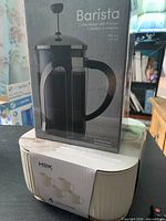 Boxed Barista French press stacked on boxed H2K mug set