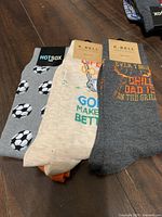 All three pairs of socks: soccer, golf, grill themes