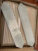 Tiles stacked in box showing mint green glazed faces with peel-off film