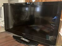 Front view of Samsung TV on stand with remote placed in front