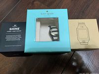Three boxed wearables: Misfit Shine, Kate Spade tracker, generic smart watch