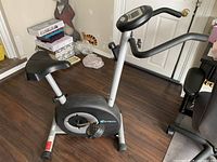 Full view of PT Fitness stationary bike showing frame, seat, pedals and handlebars