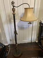 Full view of antique bridge lamp showing wooden post, cast iron bridge arm, shade and base