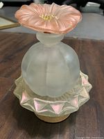 Perfume bottle on top of soap dish showing overall form and materials