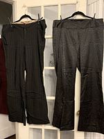 Black pinstripe pants and dark grey damask pants on hangers