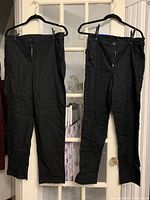 Front view of both pairs of black pants hanging, showing sizes 10 and 12.
