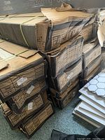 Stack of damaged cardboard cartons containing tiles