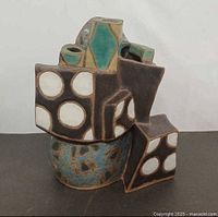 Front view showing cubist structure and white circle inlays