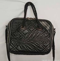 Front view of Balenciaga black leather square handbag showing quilted pattern, braided handles, logo tab