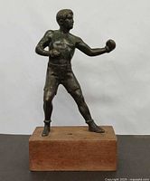 Front view of bronze boxer statue on wood base