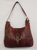 Front view of burgundy leather Etienne Aigner shoulder bag showing decorative buckle strap