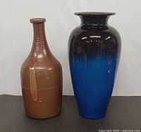 Front view of brown stoneware bottle and blue pottery vase