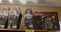 All four boxed items on shelf: three Living Dead Dolls coffins and Rocky Horror figure set