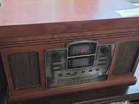 Front view showing Crosley branding, analog dial, CD controls and speaker grilles